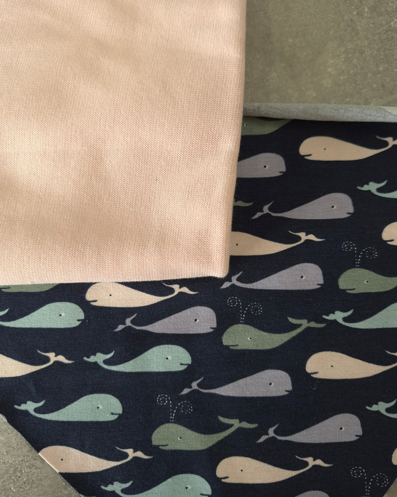 Fabric with whale pattern on a dark blue background