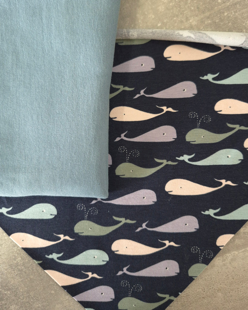 Patterned fabric with whale design on a dark background