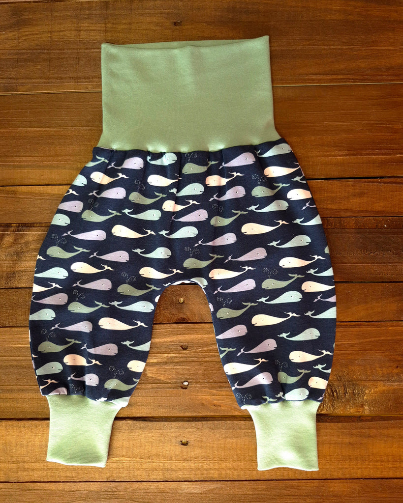 Baby trousers with whale pattern on a wooden surface