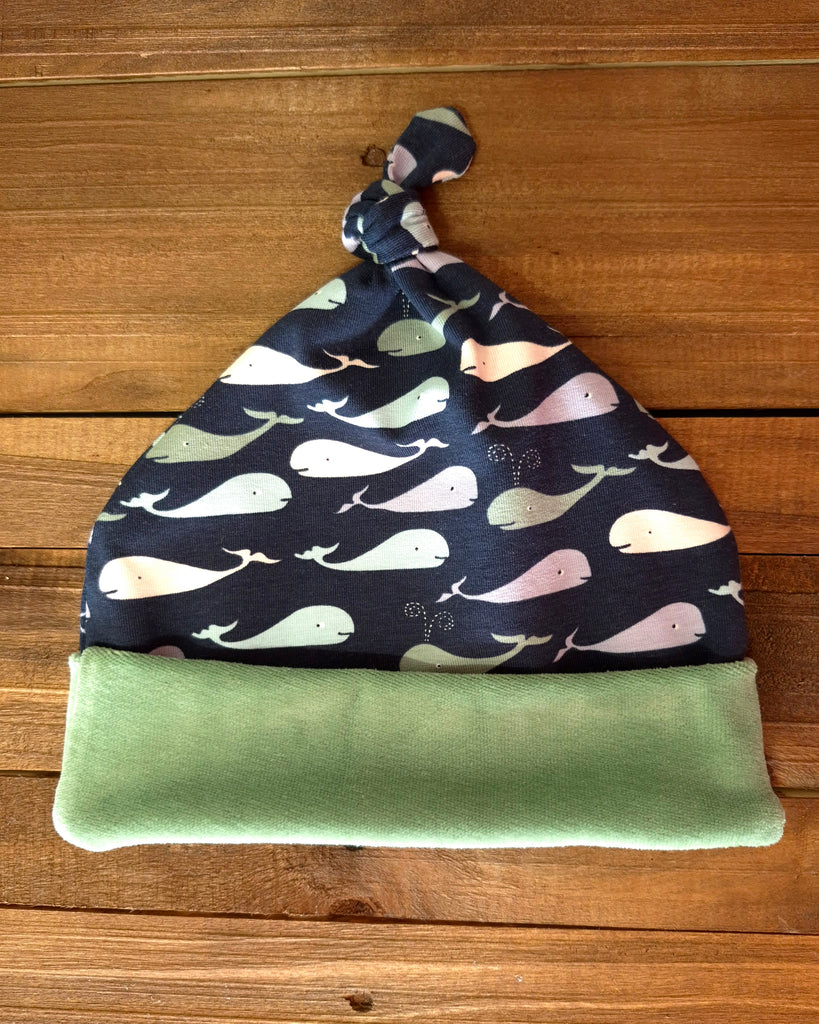 Whale print Baby knot hat with whale pattern on a wooden surface