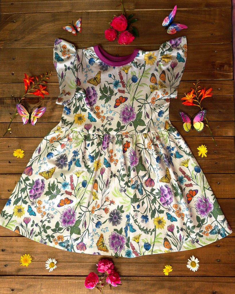 Organic cotton children's dress with hand-drawn wildflower print, flutter sleeves, and knee-length design by Cake & Elf