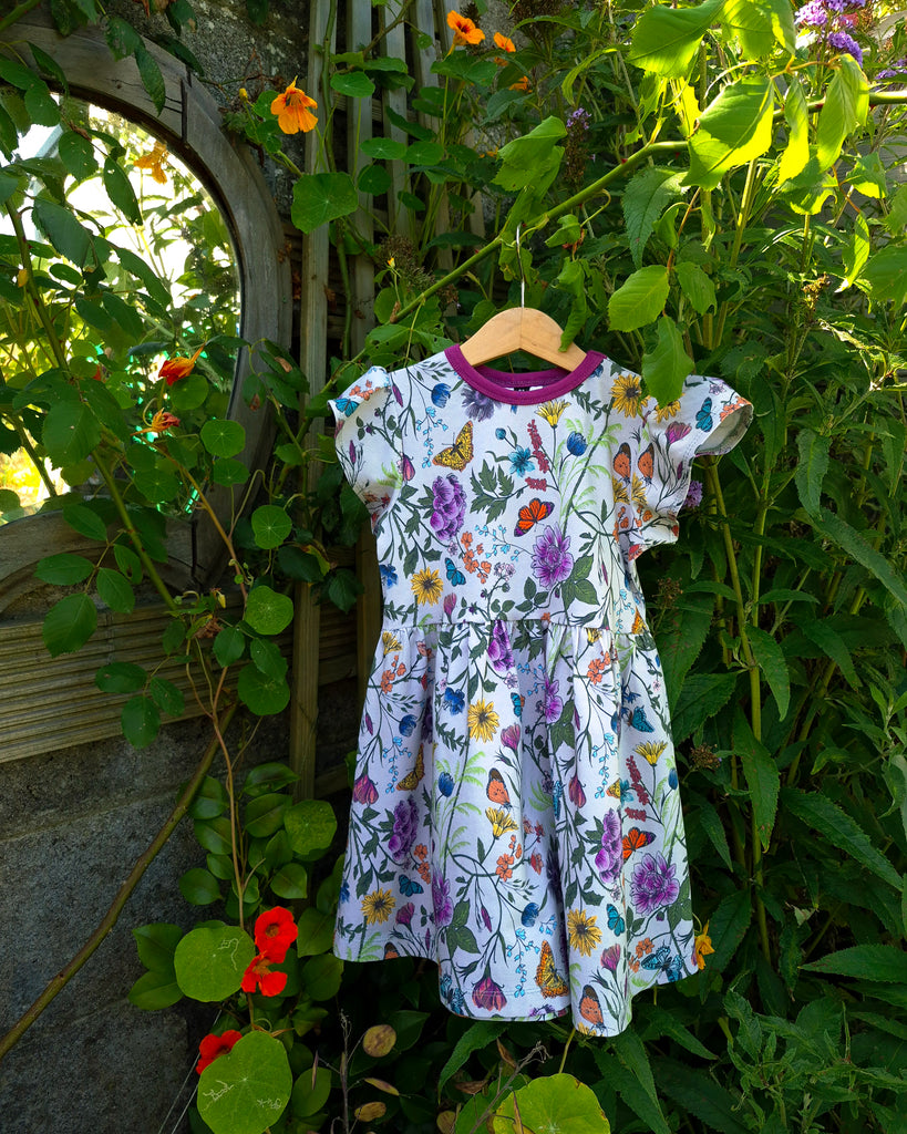 Organic cotton children's dress with hand-drawn wildflower print, flutter sleeves, and knee-length design by Cake & Elf